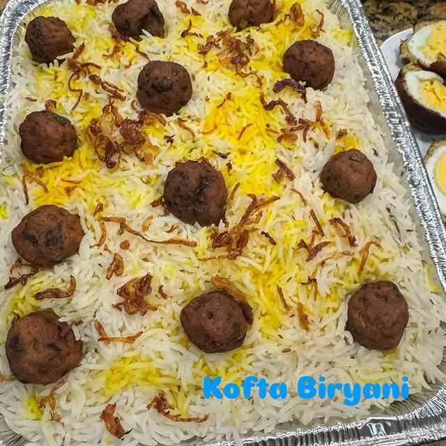 Kofta biryani topped with seasoned kofta and caramelized onions